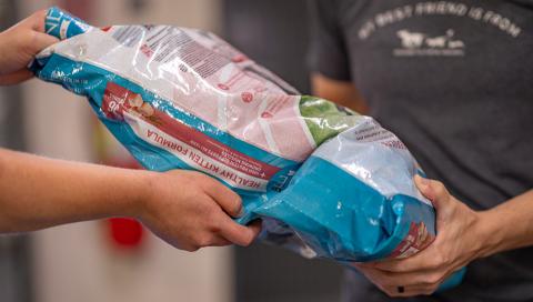 AHS employee handing out a bag of dog food.