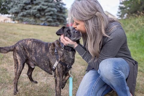 A woman kisses her dog 