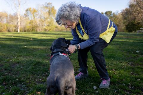 A Legacy Circle member at Animal Humane Society outside with a gray dog